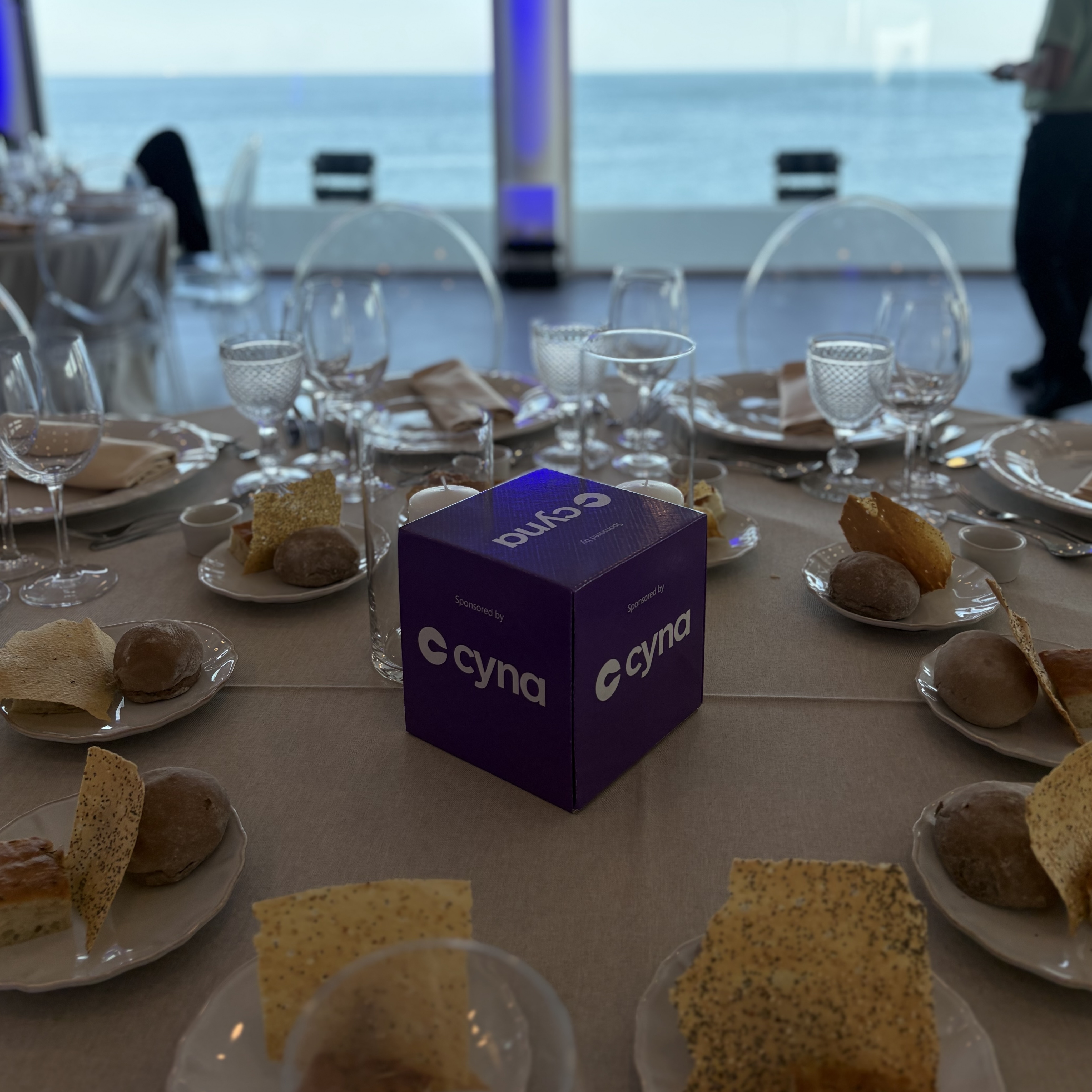 Dîner de networking du Microsoft Security Executive Partner Connect EMEA à Cascais, avec un cube aux couleurs de Cyna en centre de table face à la mer